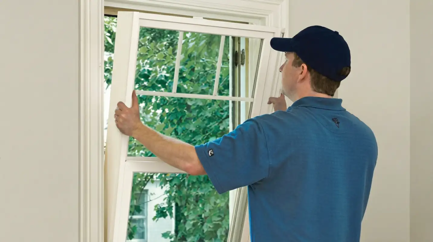 Professional contractors performing a residential window insulation and replacement service in ,